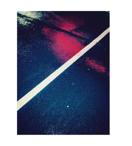 Blå yta med en vit linje och reflektioner i rött.